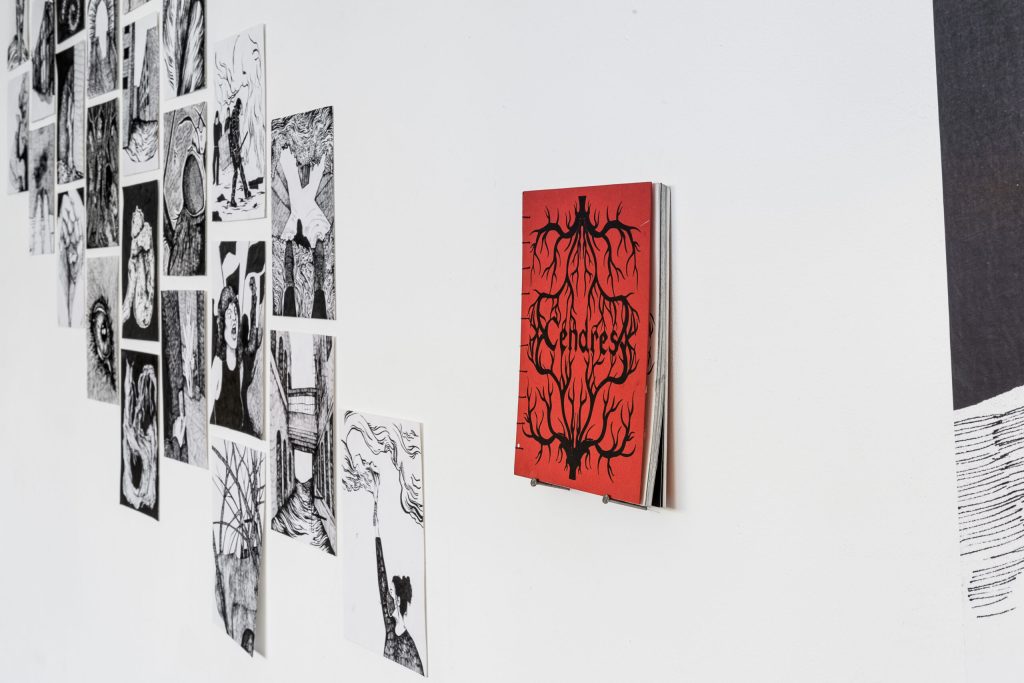 Un livre à la couverture rouge et des dessins en arrière plan