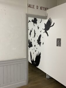 Dessin à l'encre de chine sur un mur de la galerie, représentant des corbeaux qui s'envolent