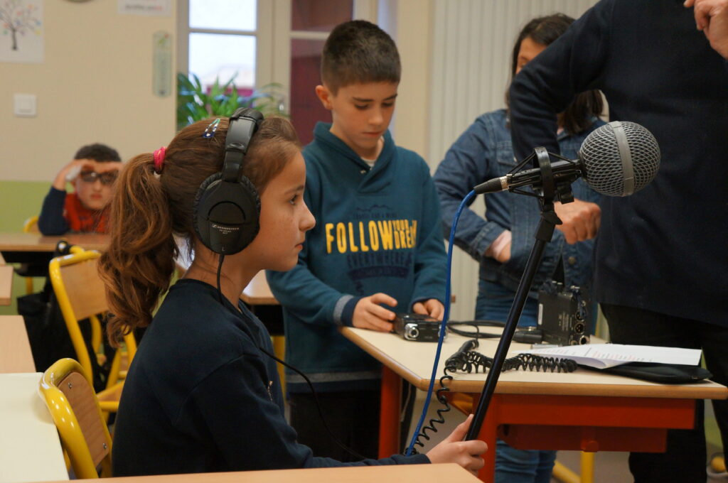 Une élève avec un casque audio écoute un morceau.